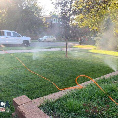 Sprinkler system watering a lush green lawn