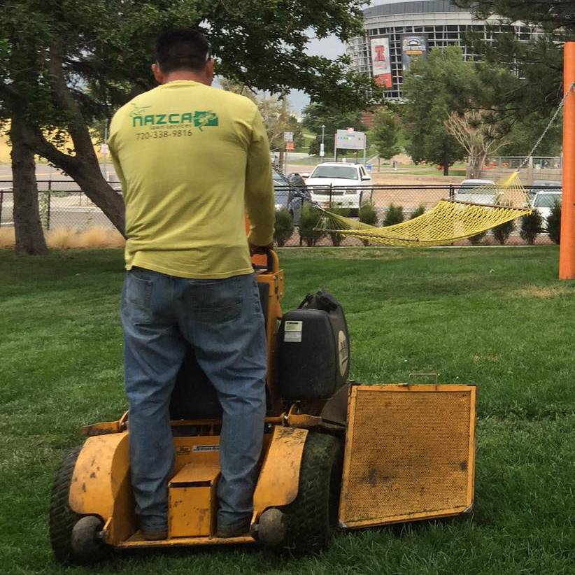 Nazca Services team member operating a professional mower